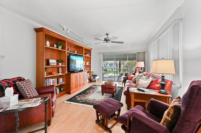 living room featuring ceiling fan, a textured ceiling, and light hardwood / wood-style flooring