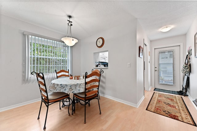 dining room featuring a textured ceiling and light hardwood / wood-style floors