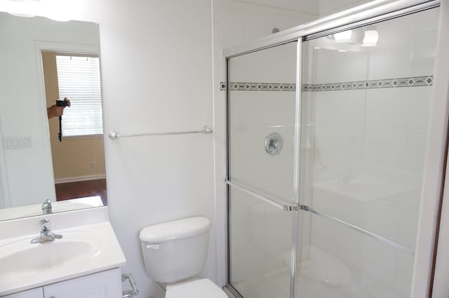 bathroom with vanity, toilet, and a shower with shower door