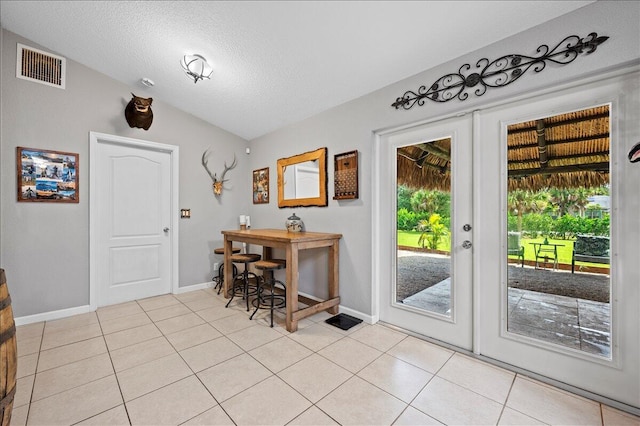 doorway to outside featuring french doors, a textured ceiling, light tile patterned flooring, and vaulted ceiling