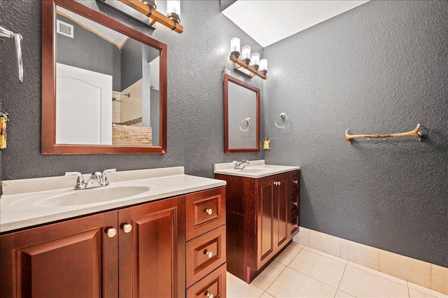 bathroom featuring vanity, a shower, vaulted ceiling with skylight, and tile patterned floors