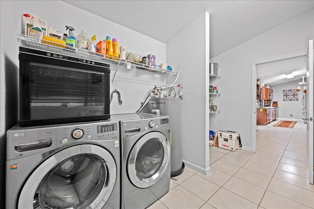 laundry room featuring water heater, light tile patterned flooring, a textured ceiling, and separate washer and dryer