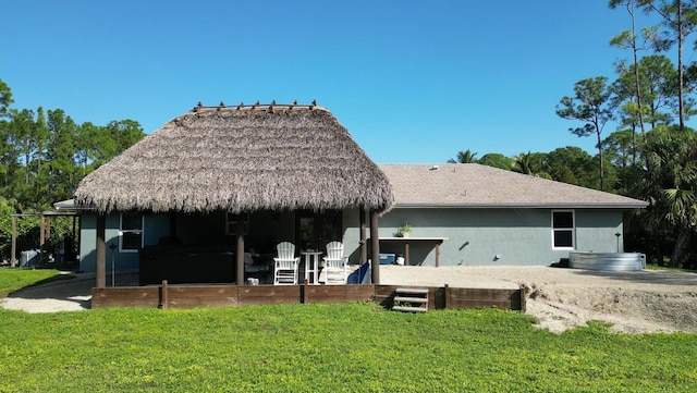 rear view of property featuring a lawn