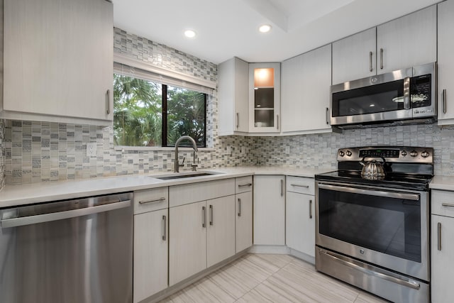 kitchen featuring backsplash, appliances with stainless steel finishes, and sink