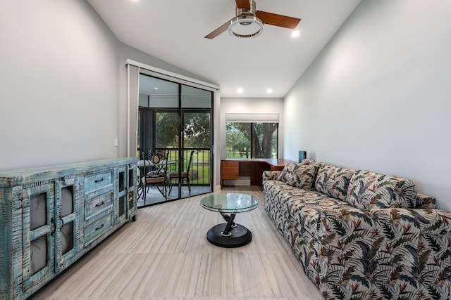 living room with ceiling fan, lofted ceiling, and light hardwood / wood-style floors