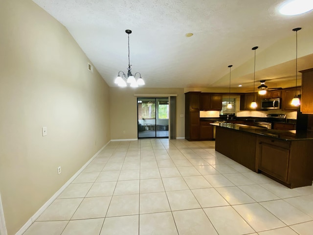 kitchen featuring ceiling fan with notable chandelier, decorative light fixtures, vaulted ceiling, and appliances with stainless steel finishes