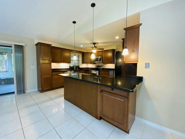 kitchen featuring decorative light fixtures, light tile patterned floors, kitchen peninsula, and appliances with stainless steel finishes