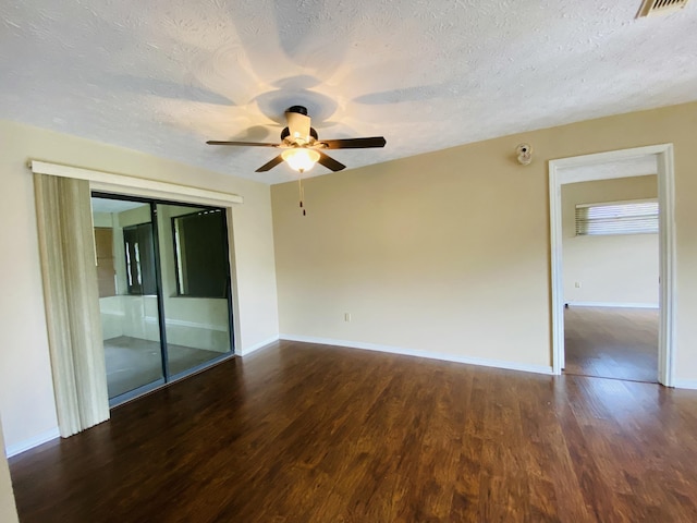 empty room with a textured ceiling, ceiling fan, and dark wood-type flooring