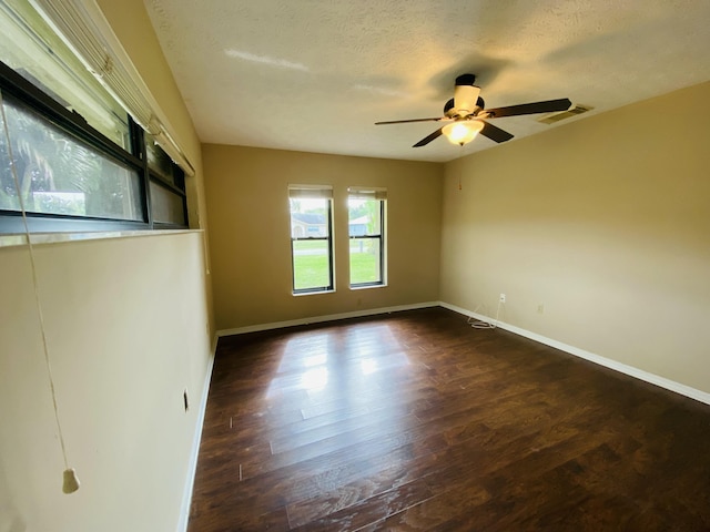 unfurnished room with a textured ceiling, dark hardwood / wood-style floors, and ceiling fan