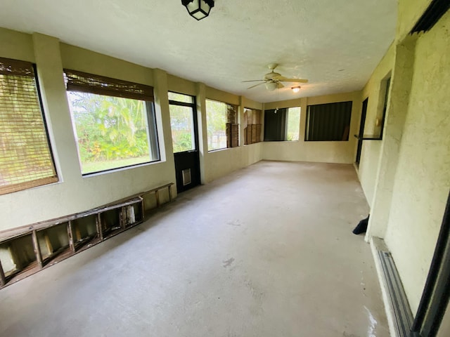 unfurnished sunroom featuring ceiling fan