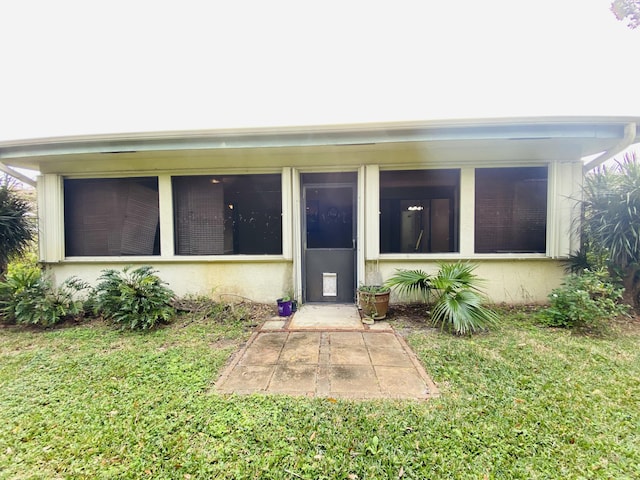 exterior space with a sunroom and a lawn