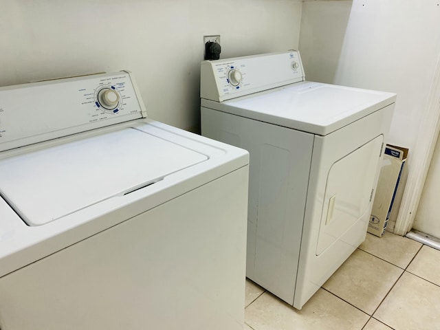 laundry area featuring light tile patterned floors and washing machine and dryer