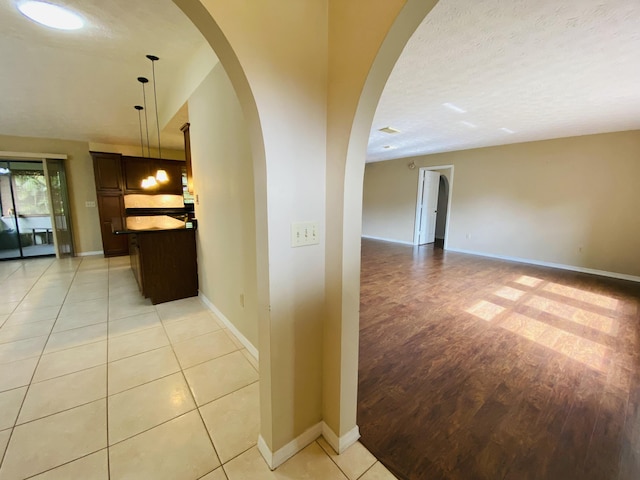 hallway featuring light tile patterned floors and a textured ceiling