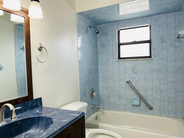 full bathroom with vanity, tiled shower / bath, and toilet