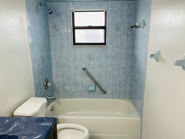 full bathroom featuring vanity, tiled shower / bath, and toilet