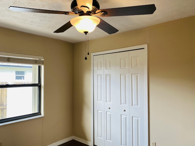 unfurnished bedroom featuring a textured ceiling, a closet, and ceiling fan