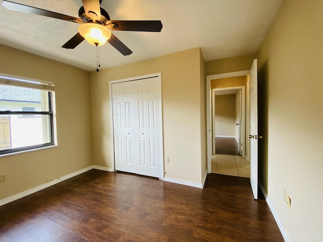 unfurnished bedroom featuring ceiling fan, dark wood-type flooring, and a closet