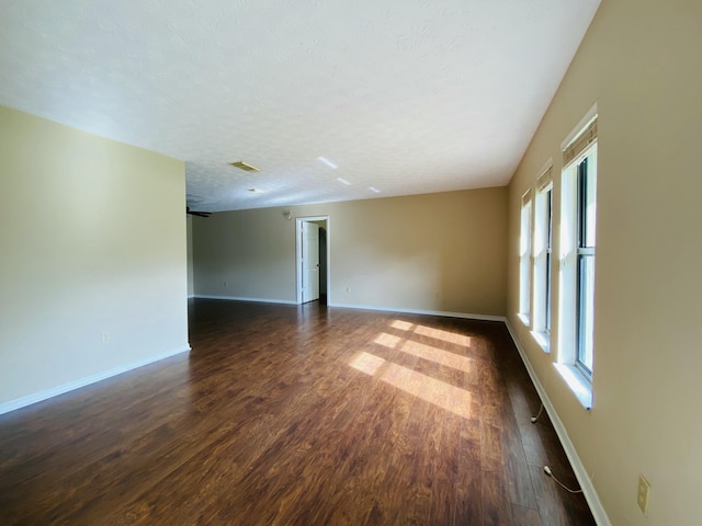 empty room featuring dark hardwood / wood-style flooring and a textured ceiling