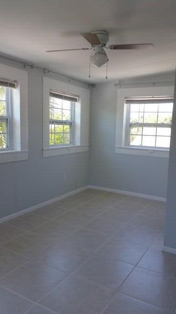 unfurnished room featuring ceiling fan and tile patterned flooring