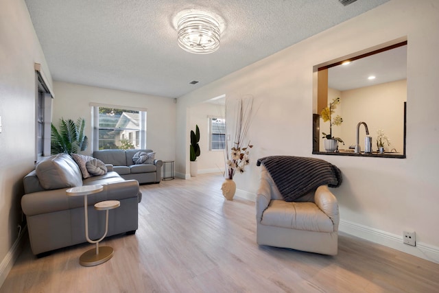 living room with light hardwood / wood-style floors and a textured ceiling