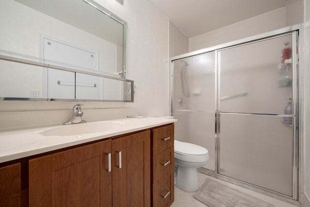 bathroom with vanity, toilet, tile patterned floors, and a shower with shower door