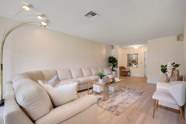 living room with light hardwood / wood-style floors and a textured ceiling