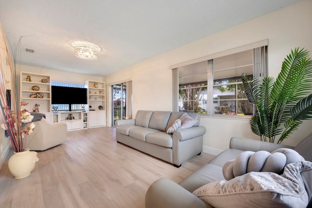 living room with light hardwood / wood-style flooring and a textured ceiling