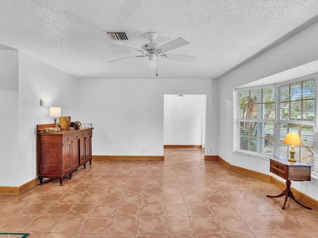 interior space with ceiling fan and a textured ceiling