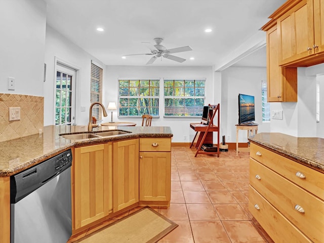 kitchen with stone countertops, kitchen peninsula, sink, stainless steel dishwasher, and tasteful backsplash