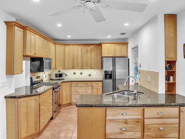 kitchen featuring appliances with stainless steel finishes, kitchen peninsula, and dark stone counters