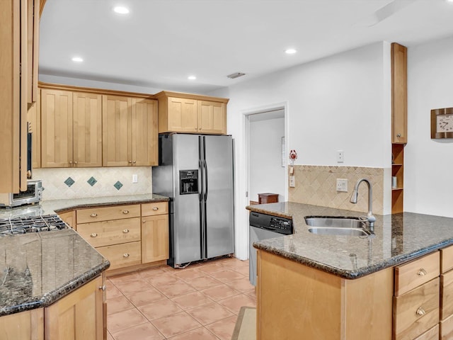 kitchen featuring sink, backsplash, kitchen peninsula, stainless steel appliances, and dark stone counters