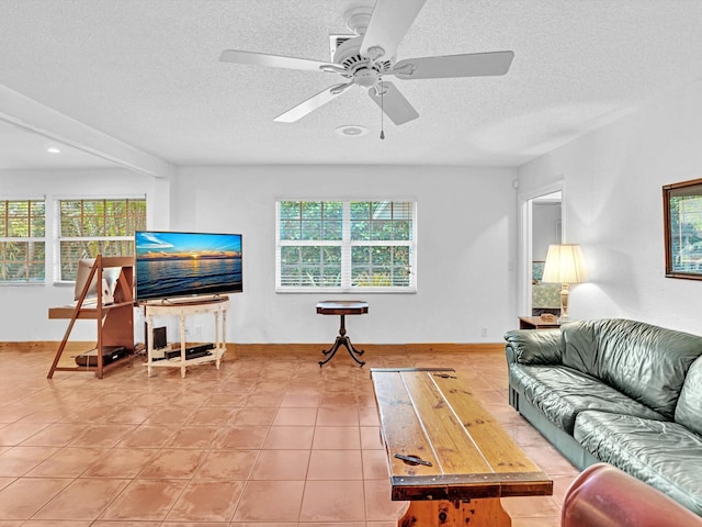 living room featuring a textured ceiling, ceiling fan, and a wealth of natural light