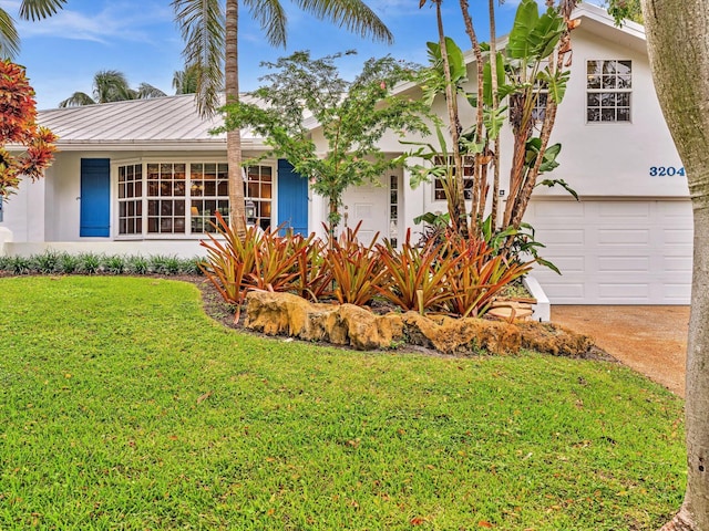 view of front of home with a front lawn and a garage