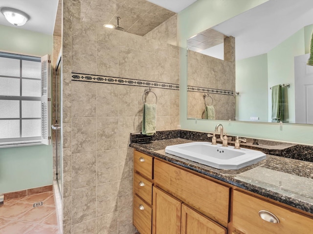 bathroom with vanity, a tile shower, and tile patterned floors