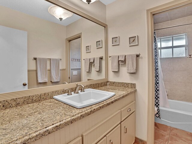 bathroom with vanity, shower / bathtub combination with curtain, a textured ceiling, and tile patterned flooring