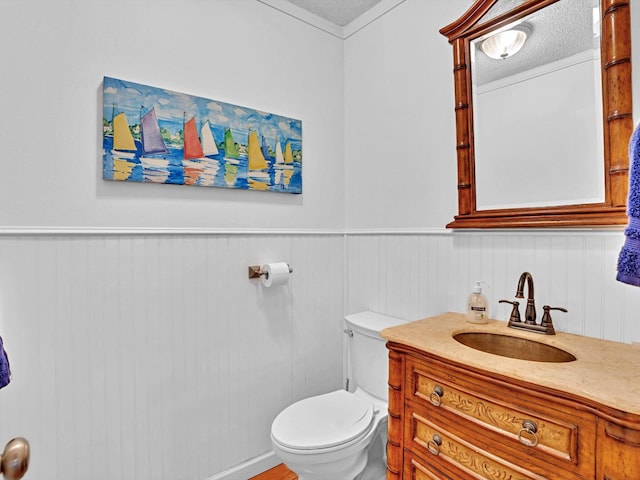 bathroom featuring toilet, a textured ceiling, and vanity