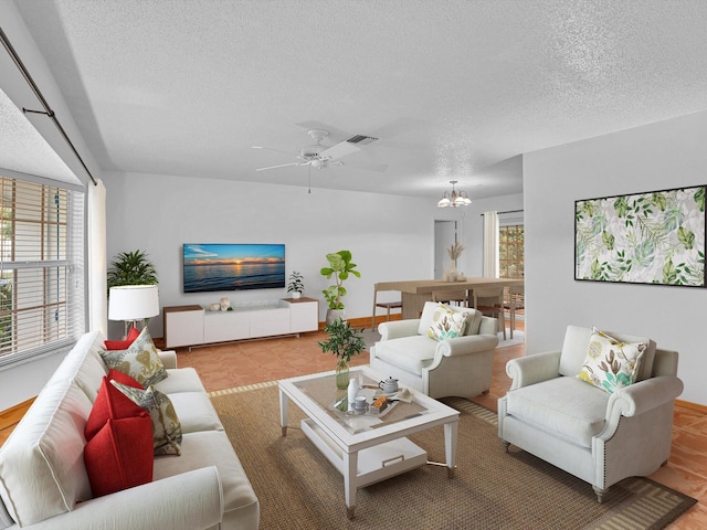 living room with hardwood / wood-style flooring, a textured ceiling, and ceiling fan with notable chandelier