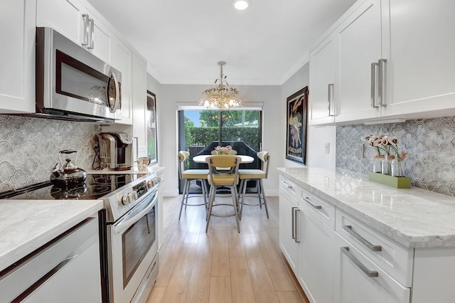 kitchen with a notable chandelier, white cabinets, and stainless steel appliances