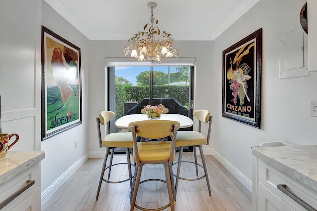 dining room with light hardwood / wood-style floors, ornamental molding, and a chandelier