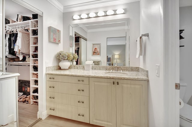 bathroom with vanity, toilet, and crown molding