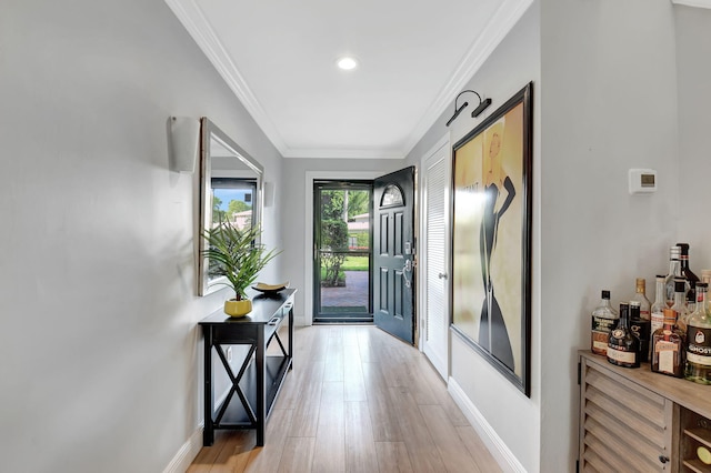 foyer entrance with light hardwood / wood-style flooring and ornamental molding