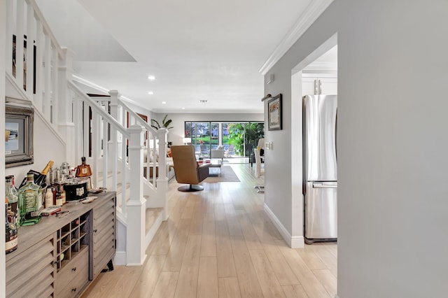 hallway with ornamental molding and light hardwood / wood-style flooring