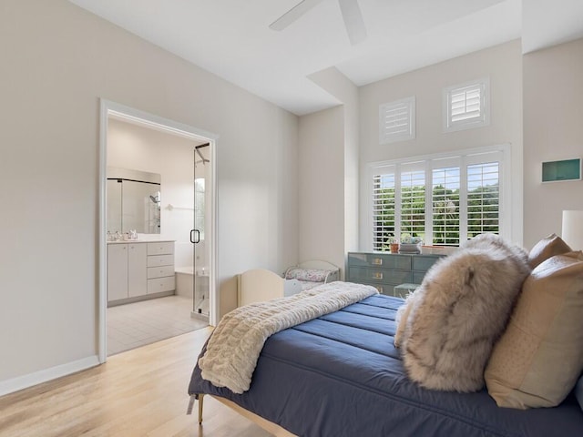 bedroom featuring ceiling fan, light hardwood / wood-style flooring, and ensuite bath