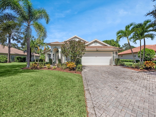 mediterranean / spanish home featuring a front yard and a garage