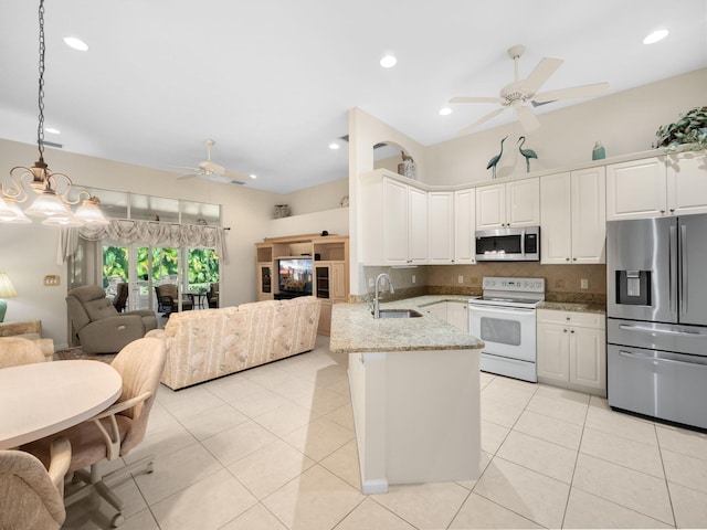 kitchen featuring white cabinets, light stone countertops, sink, pendant lighting, and stainless steel appliances