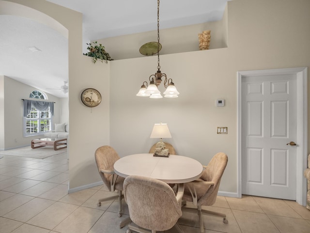 dining room featuring light tile patterned floors, vaulted ceiling, and ceiling fan with notable chandelier