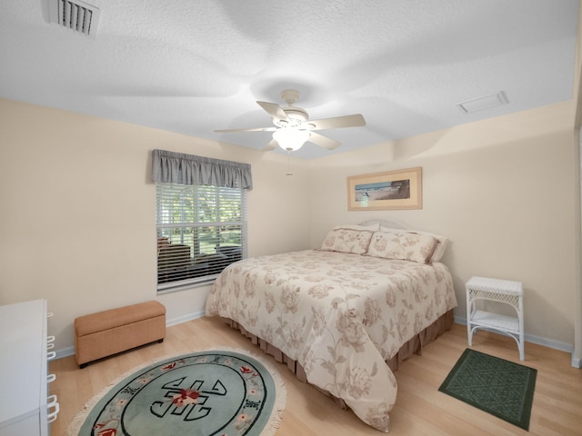 bedroom featuring a textured ceiling, light hardwood / wood-style floors, and ceiling fan