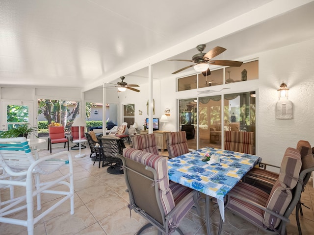 interior space with lofted ceiling with beams, light tile patterned flooring, and ceiling fan