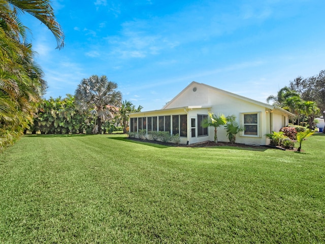 rear view of house with a yard and a sunroom