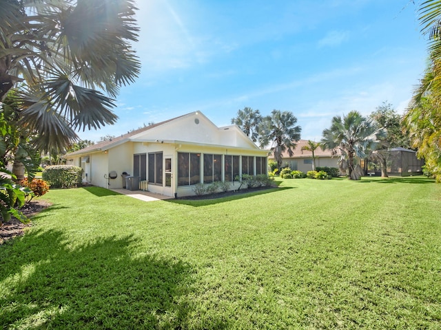 back of property with a yard and a sunroom